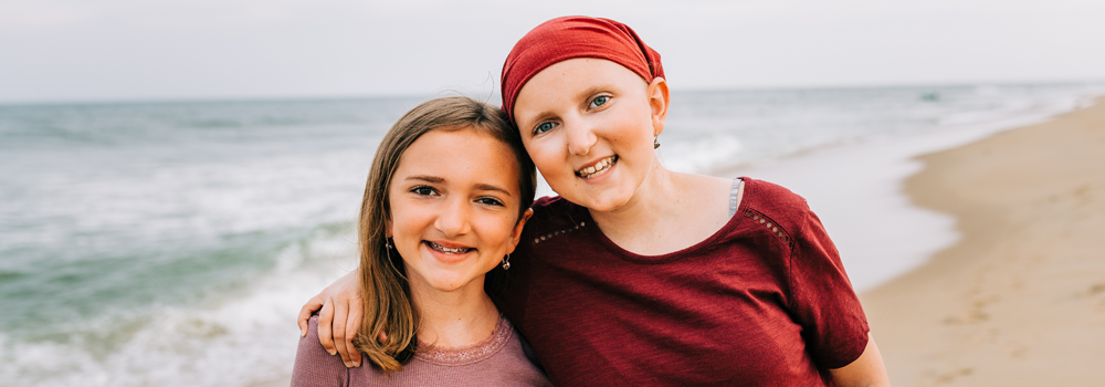 Sisters smiling on the beach enjoying Believe In Tomorrow Programs