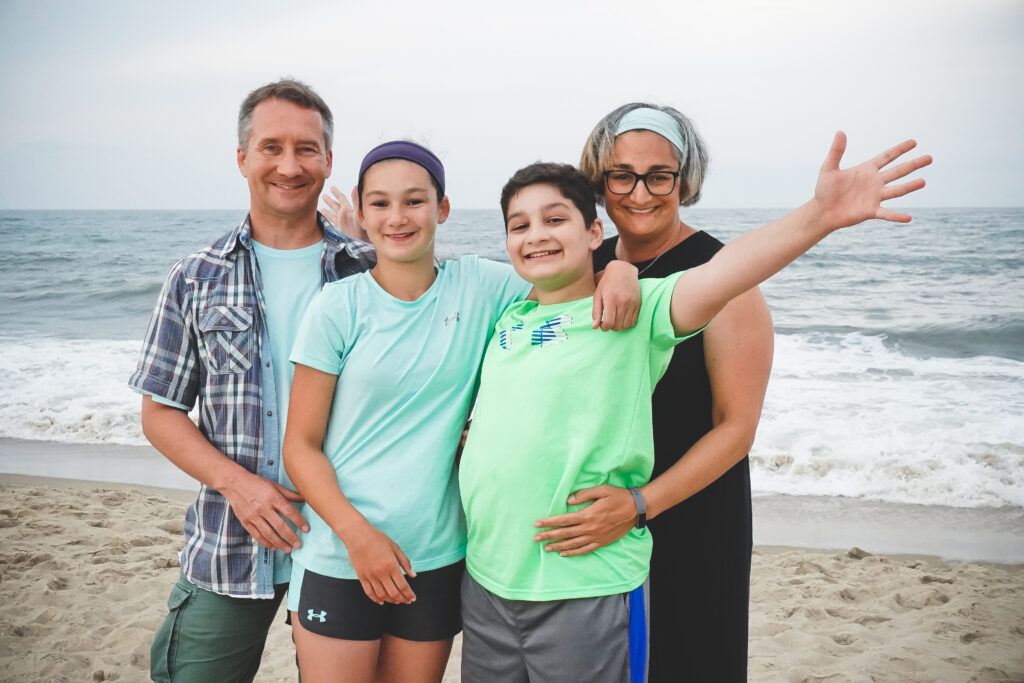 A family enjoying the beach on a Believe In Tomorrow respite trip
